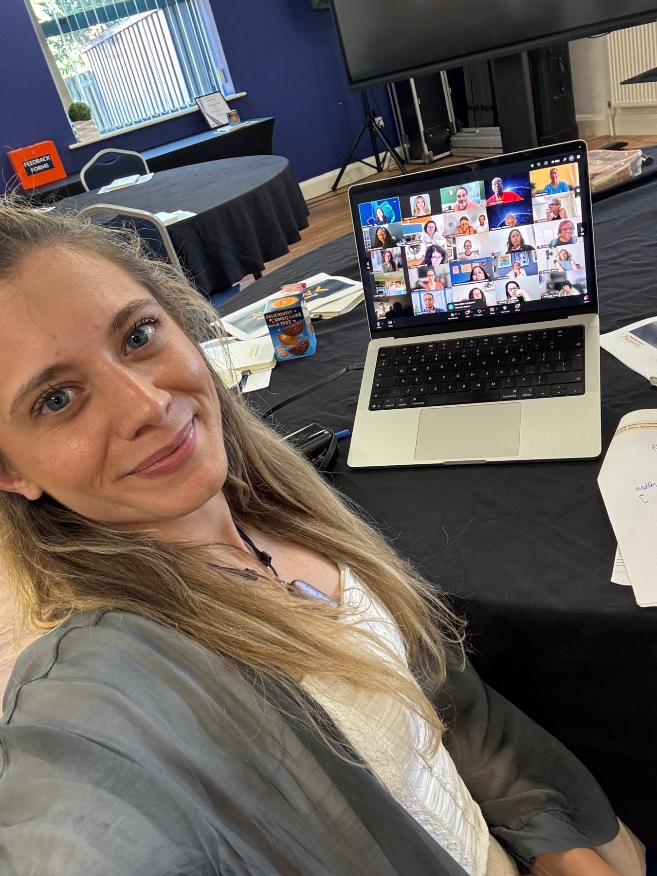 Sabrina at a laptop with a full Zoom grid